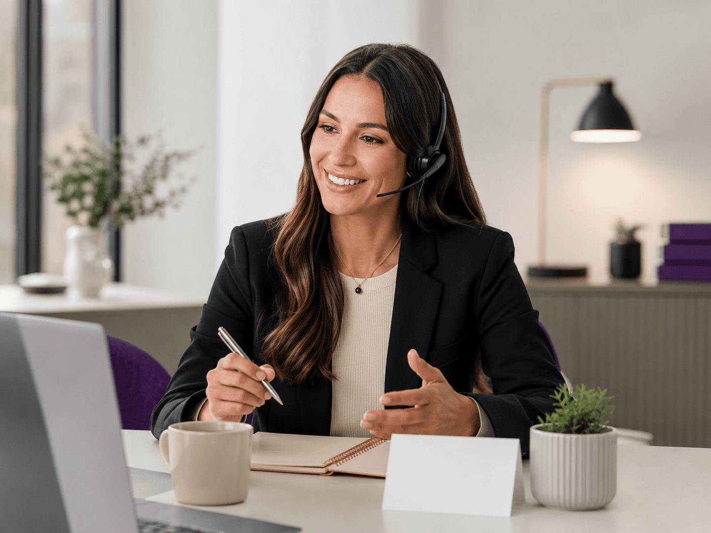 Support team member wearing a headset while taking notes during a call.
